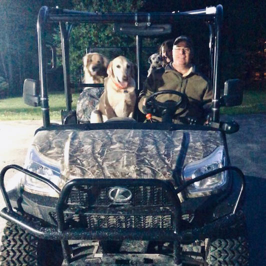 Randy with family dogs on golf cart