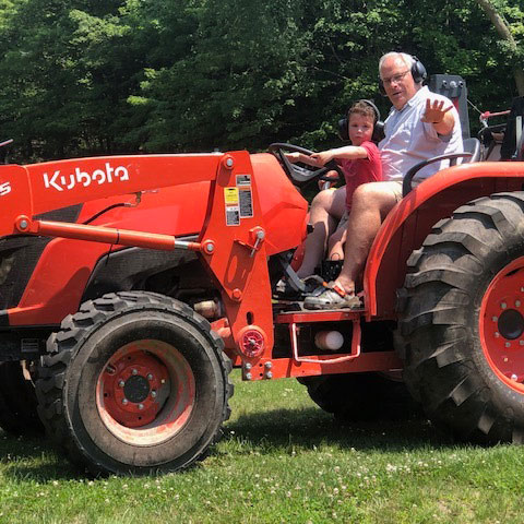 Randy on tractor with family member
